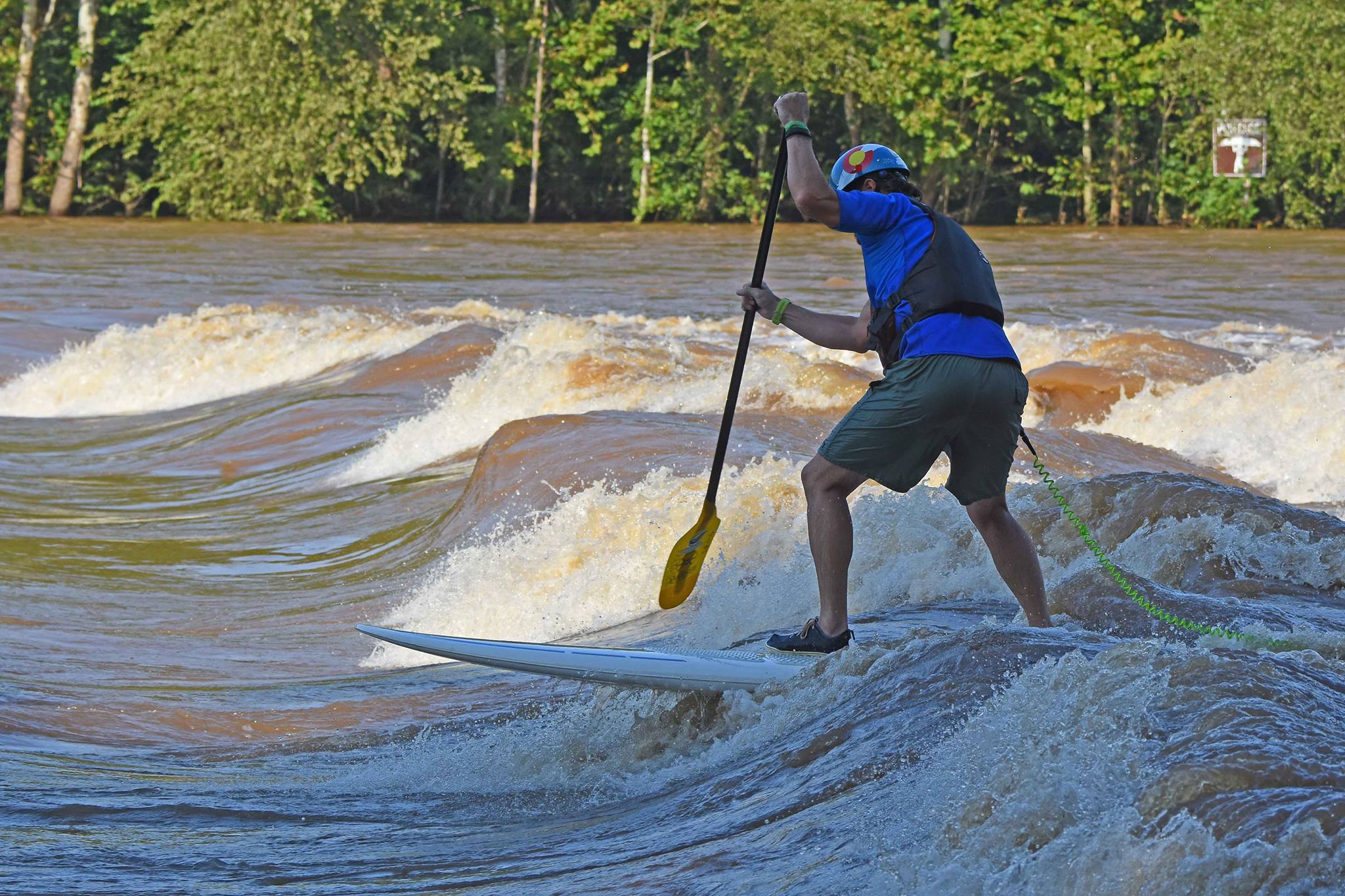 Man stand up paddleboarding on a river