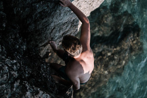 Athlete free solo climbing on a rock face