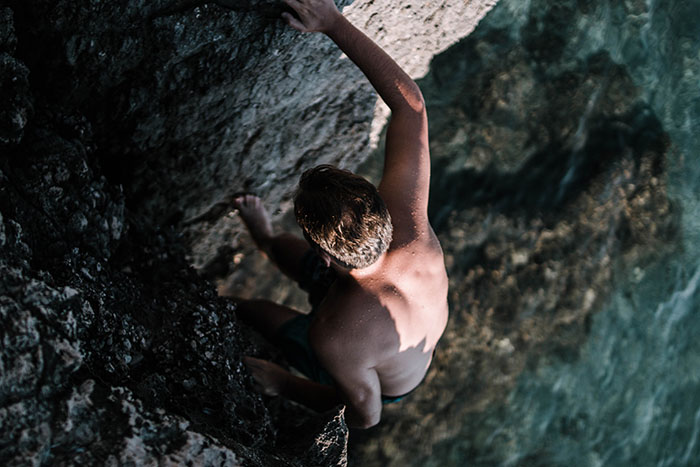 Athlete free solo climbing on a rock face