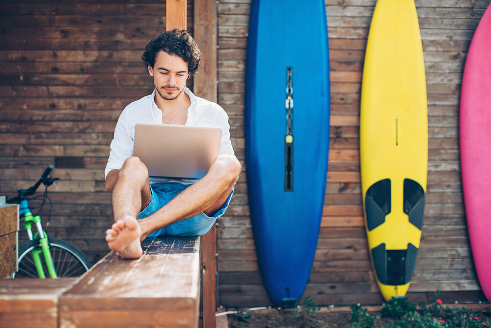 Owner of small business surf shop on laptop